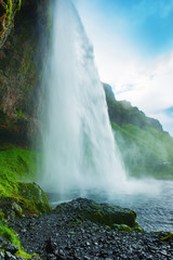 Famous waterfall Seljalandsfoss in Iceland, adventure outdoor travel Icelandic summer background