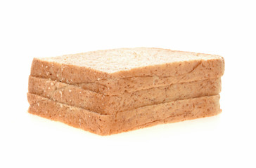 Whole wheat bread stacked on white background.