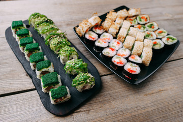 Japanese traditional cuisine. Food photo art, professional culinary, seafood restaurant menu. Appetizing tasty great sushi set served on black plates, top view.