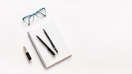 Naklejka premium Notebook with pen, pencil, glasses and lipstick