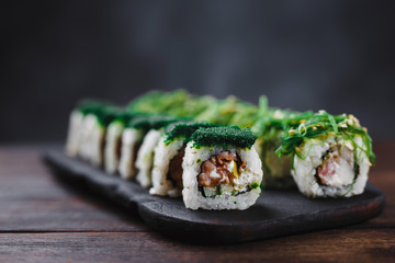 Japanese cuisine, seafood, restaurant menu, food photo art. Delicious sushi rolls set served on wooden tray