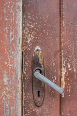 Vintage Handle on a Red Aged Wooden Door
