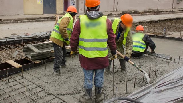 Concrete works for road maintenance construction with many workers and mixer timelapse