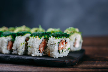 Japanese food art, sushi restaurant, traditional cuisine. Delicious sushi rolls set served on wooden tray with free space for text design