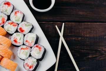 Japanese food, sushi restaurant. Delicious sushi rolls set served on white plate with free space for text design