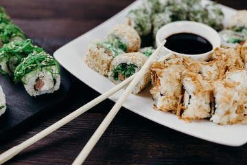 Food photo art, traditional  japanese seafood, restaurant menu. Tasty great colorful set of fresh sushi maki rolls with salmon, tuna and avocado served on white porcelain pate