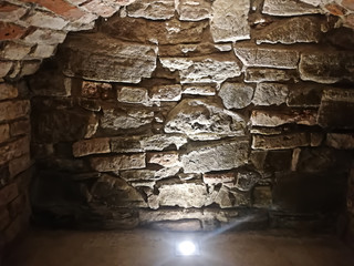 stone wall underground with a lamp on the floor background