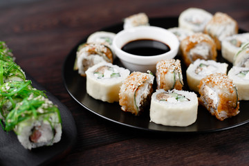 Japanese restaurant menu, professional culinary, traditional meals. Delicious sushi rolls with eel, chuka seaweed, tuna and philadelphia cheese, close up. Delicious meals for foodie