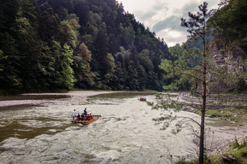 Raft with tourist on river in mountains during cloudy day, Pieniny Poland