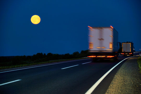 Truck Driving On Country Road By Moonlight