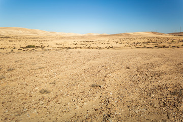 Panorama of far desert hills under blue sky