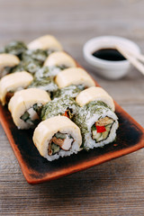 Appetizing maki sushi rolls set served on original clay plates. Restaurant menu, Japanese traditional meals, healthy food