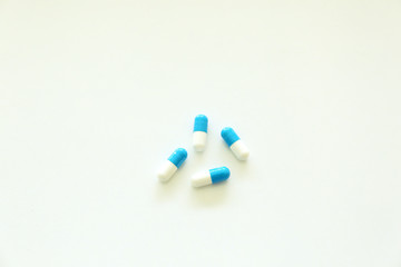 Capsules, white and blue. White background.