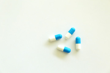 Capsules, white and blue. White background.