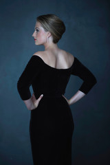 Retro 1950s woman in black evening dress. Rear view.