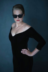 Retro 1950s woman in black dress and sunglasses.
