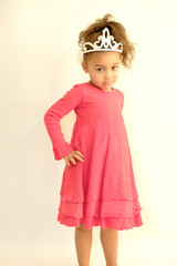 Little girl in pink dress and tiara fun poses