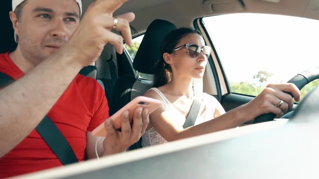 Couple using smartphone navigation app in the car on vacation
