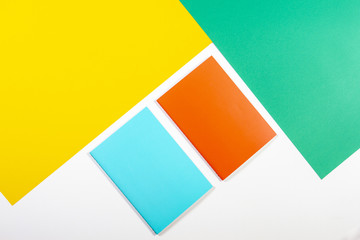 Colorful notebooks on green yellow white background.