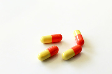 Yellow-red capsules. Some capsules and pills isolated on white background