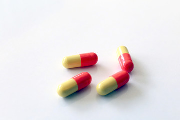 Yellow-red capsules. Some capsules and pills isolated on white background