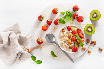healthy breakfast with oatmeal porridge, strawberry, nuts. Top view