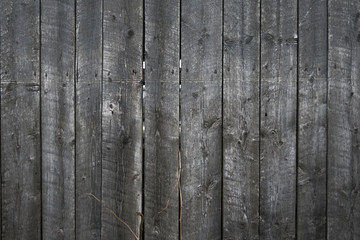 Grungy background of peeling flaking black paint on wooden boards