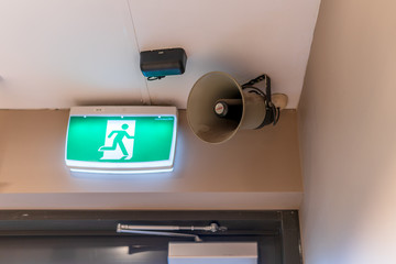 Emergency exit sign and speaker in the building.