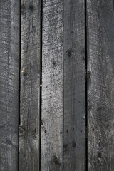 Grungy background of peeling flaking black paint on wooden boards