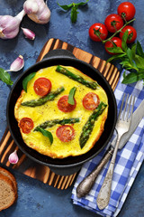 Good morning. Omelet with asparagus and tomatoes for breakfast with toast and coffee on a blue background.