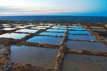 Salt pans cut into the rock on the coast with the horizon in the background