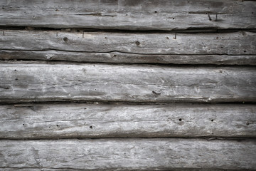 Rough old weathered log cabin background wall closeup