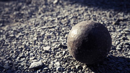 Old petanque balls on the ground. Steel ball on the ground. Light and shadow.