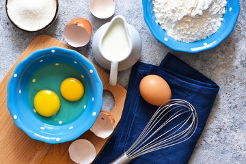 Food background. Ingredients for baking: flour, eggs, berries, chocolate on a concrete background.