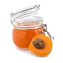 Glass jar with tasty apricot jam on white background