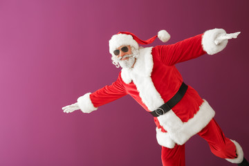 Fototapeta na wymiar Cool Santa Claus on color background