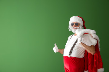 Fototapeta na wymiar Portrait of cool Santa Claus on color background