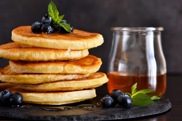 Homemade oat pancakes with honey and blueberries for breakfast on a stone plate. Good morning!