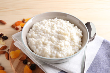 Delicious rice pudding in bowl on wooden table