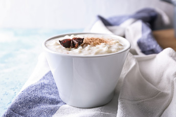 Delicious rice pudding with cinnamon and anise in bowl on table