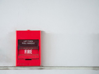 Push button switch, fire alarm on grey wall for alarm and security system with fire extinguisher...