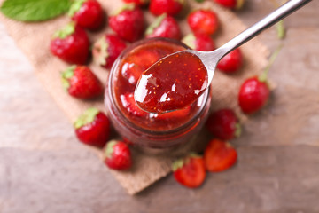 Spoon with delicious strawberry jam, closeup