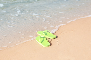 Bright flip-flops on sea beach