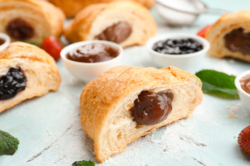 Tasty croissant with jam on light table, closeup