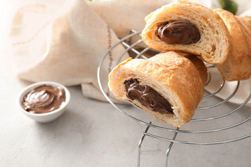 Tasty croissant with chocolate cream on cooling  rack