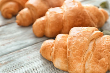 Tasty croissants on wooden table, closeup