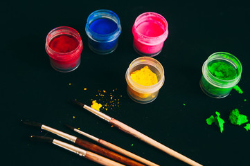 Gouache on black background. Blue, yellow and green red gouache. A set of gouache