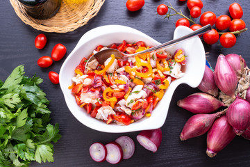 Insalata di baccalà alla catalana nel contenitore a forma di pesce in ceramica bianca