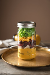 Delicious vegetable salad in mason jar on metal tray