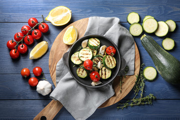 Pan with tasty grilled zucchini and tomatoes on table